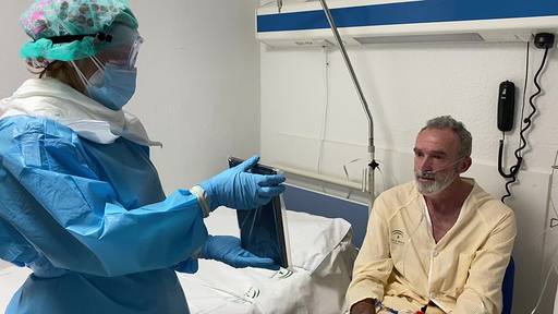 Profesional sanitaria junto a un paciente ayudándole a comunicarse con sus familiares | Fuente: Hospital Regional de Málaga 